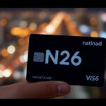 N26 Mastercard in einer Hand vor Stadtlichtern